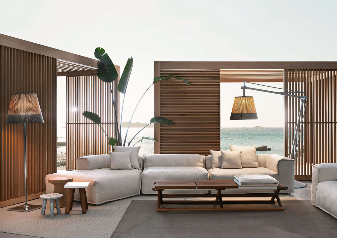 Een woonkamer met een bank, tafel, lamp en uitzicht op de oceaan.