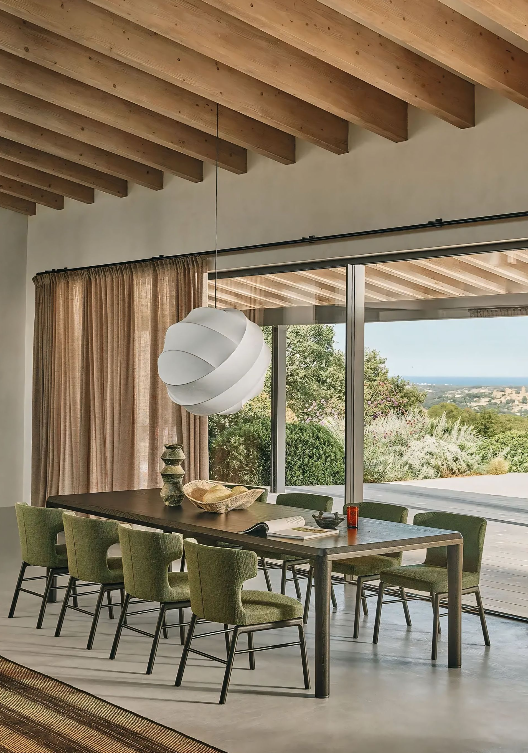 Een eetkamer met een tafel en stoelen en een groot raam.