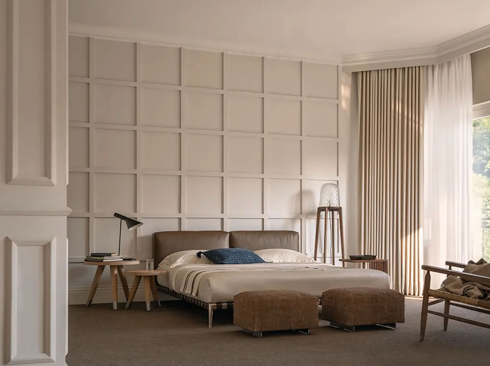 Een slaapkamer met een groot bed en twee voetenbankjes