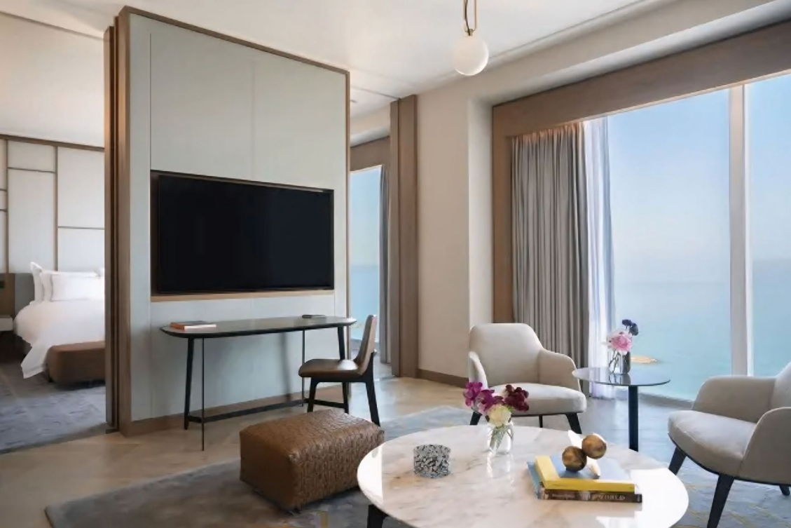 Een woonkamer met een grote flatscreen-tv aan de muur.
