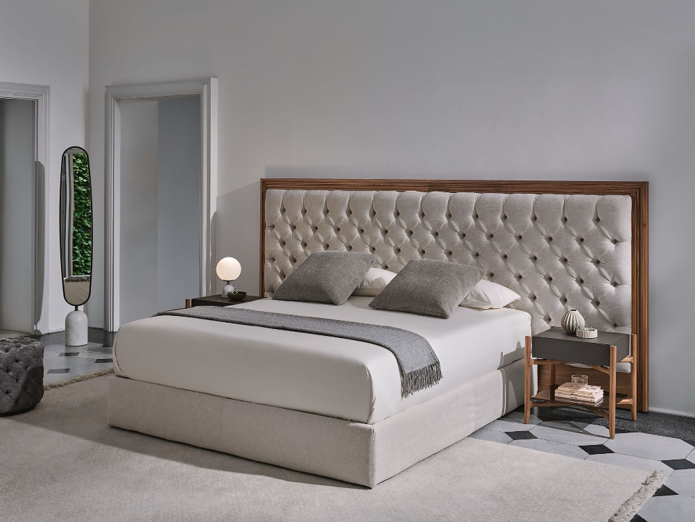 Een slaapkamer met een bed, twee nachtkastjes en een spiegel.
