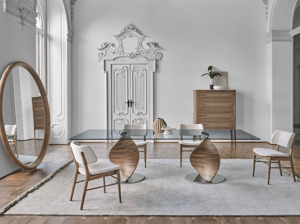 Een woonkamer met stoelen, een tafel en een spiegel