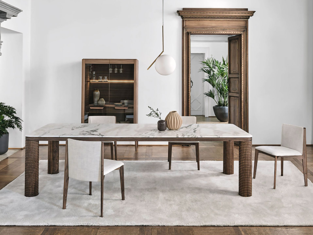 Een eetkamer met een marmeren tafel en stoelen