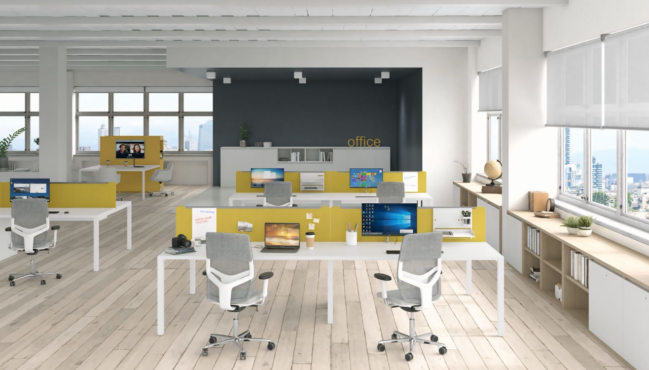 Een groot kantoor met veel bureaus en stoelen en veel ramen.
