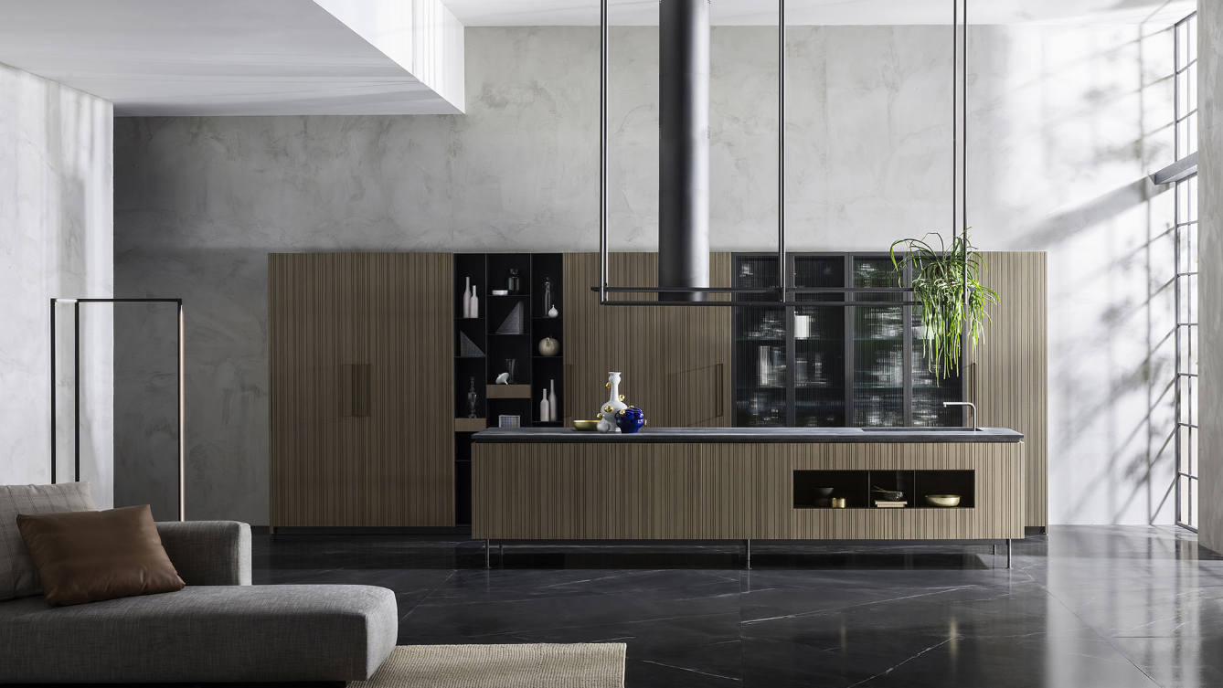 Een woonkamer met een bank en een keuken op de achtergrond.