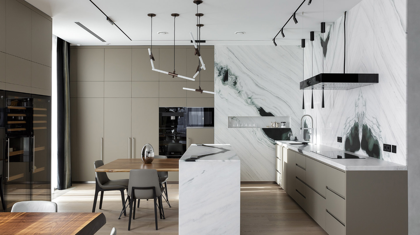 Een keuken met een eettafel en stoelen en een groot kookeiland in het midden van de kamer.