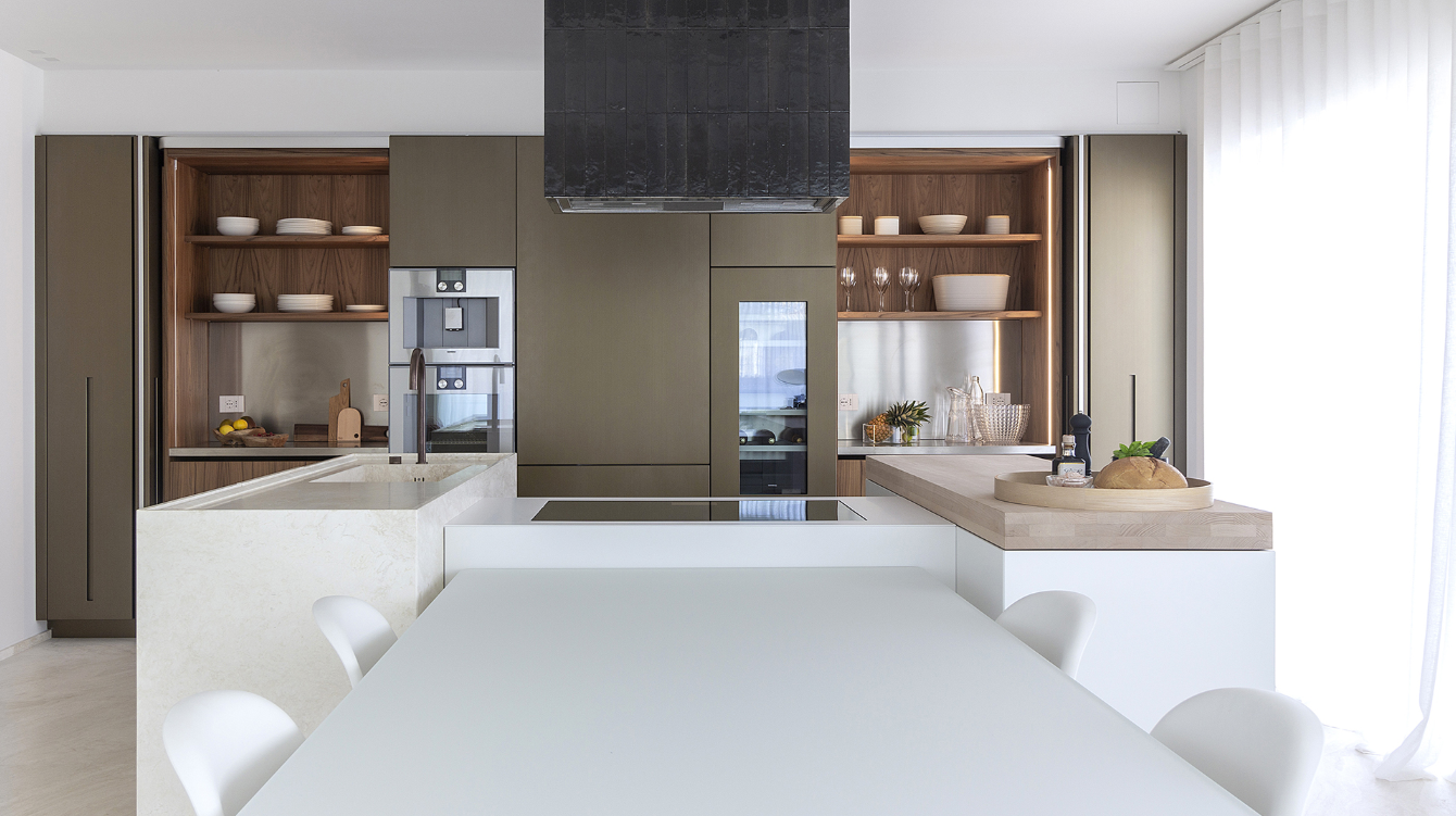 Een keuken met een tafel, stoelen en een groot kookeiland.