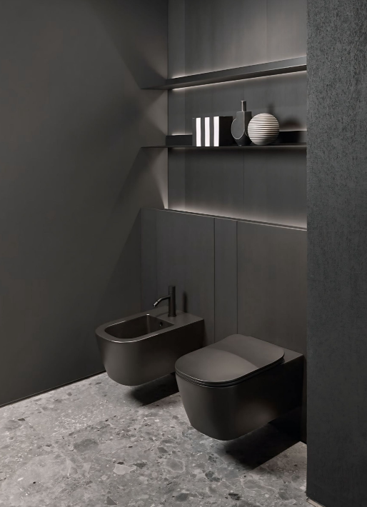Een badkamer met twee zwarte toiletten en een bidet.