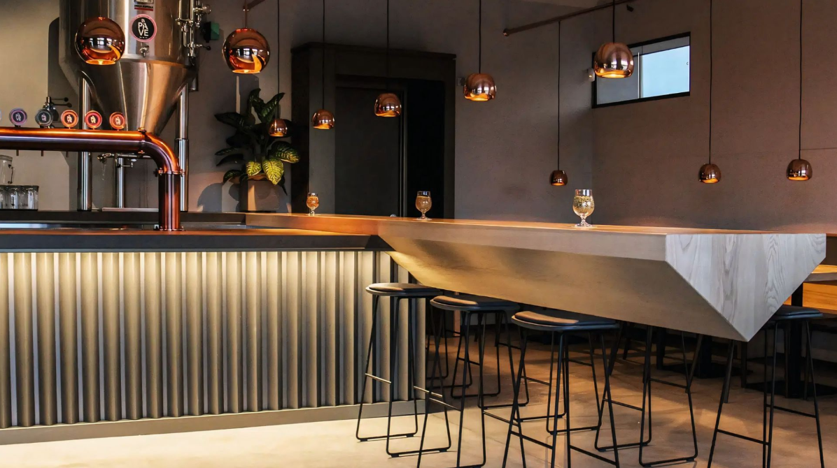 Een bar met een lange bar en krukken in een restaurant.