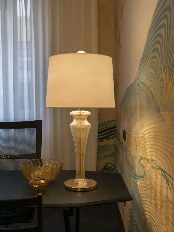 Er staat een lamp op een tafel naast een schaal.