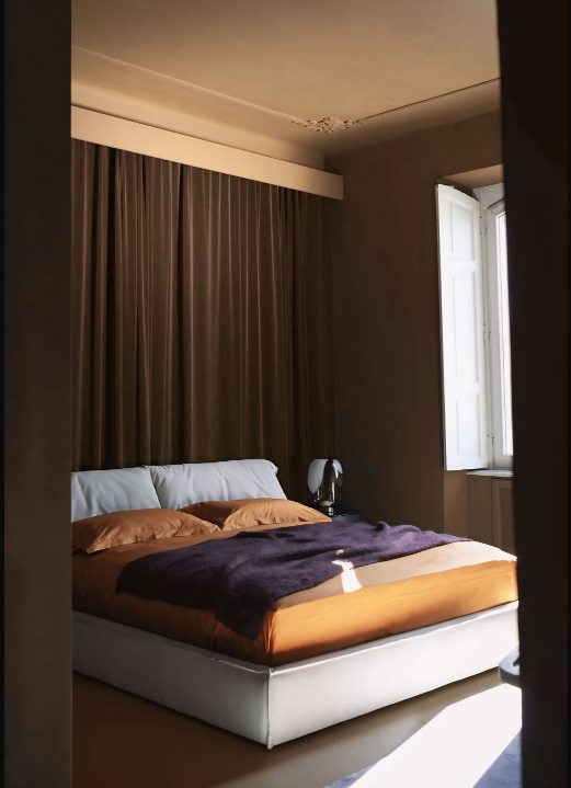 Een slaapkamer met een groot bed en bruine gordijnen