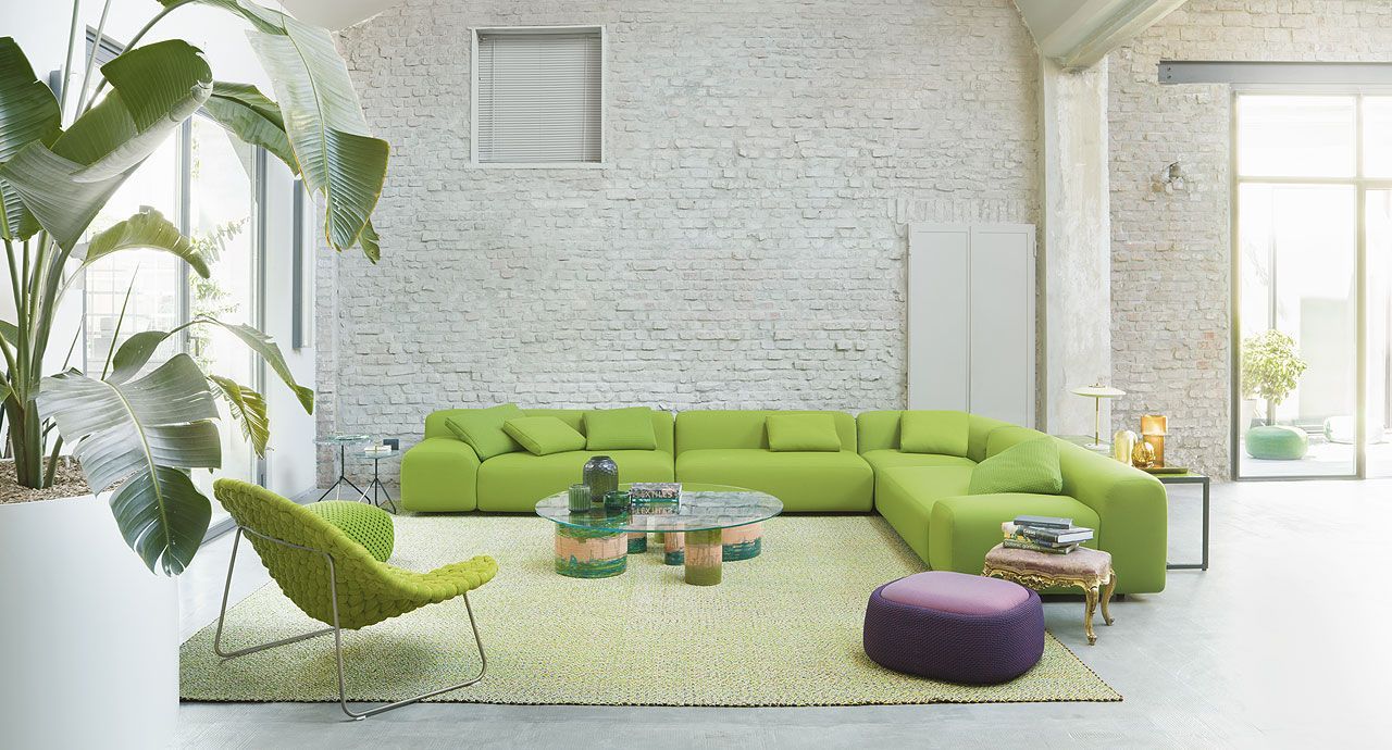 Een woonkamer met een groene bank en een paarse stoel.