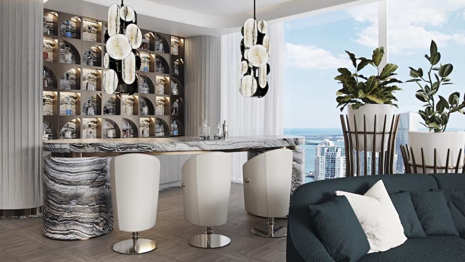 Een woonkamer met een bank, stoelen, een bar en uitzicht op de oceaan.