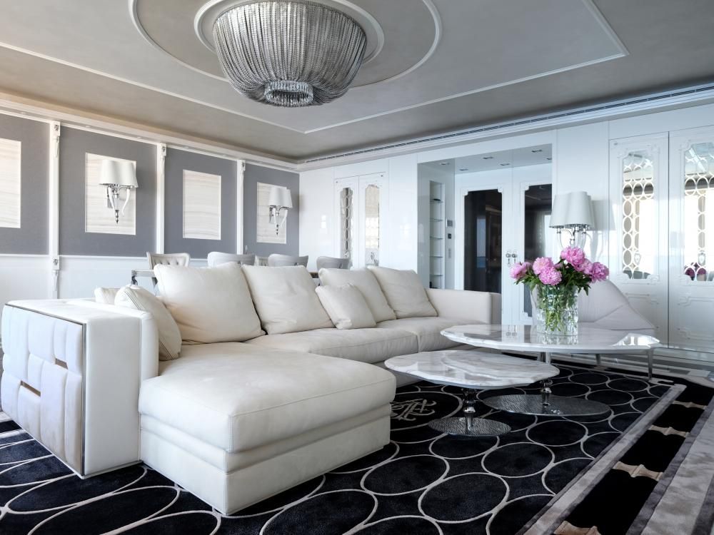 Een woonkamer met witte meubels en een zwart-wit tapijt