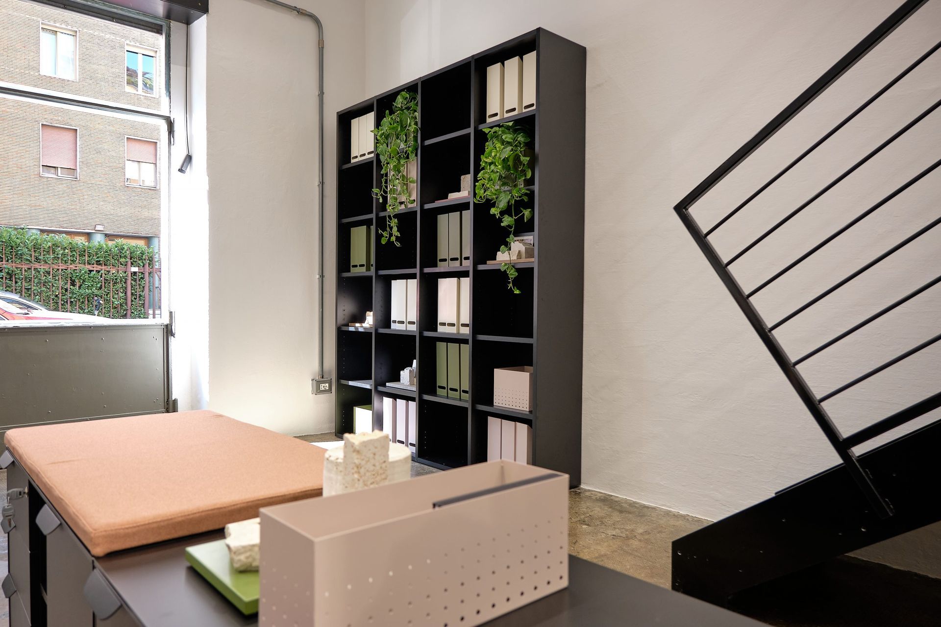 Een kamer met een tafel, planken en een trap.