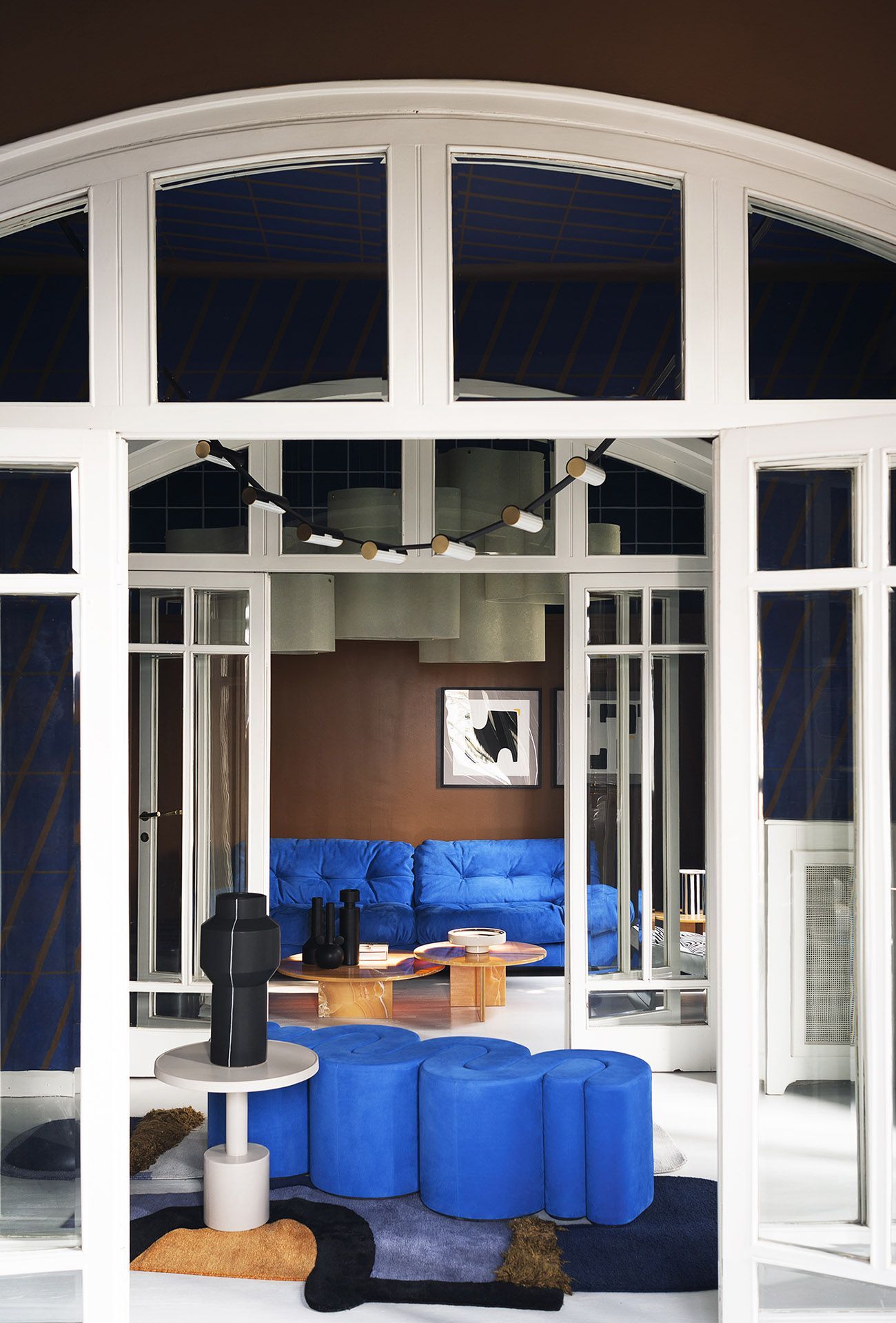 Een woonkamer met een blauwe bank en blauwe voetenbankjes