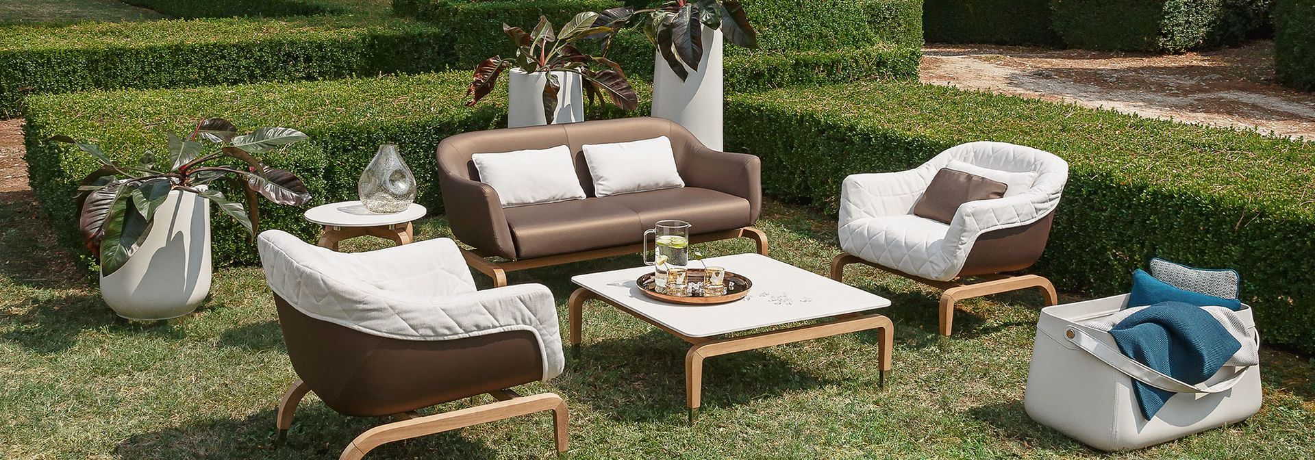 Een gazon met een bank, stoelen en een salontafel.