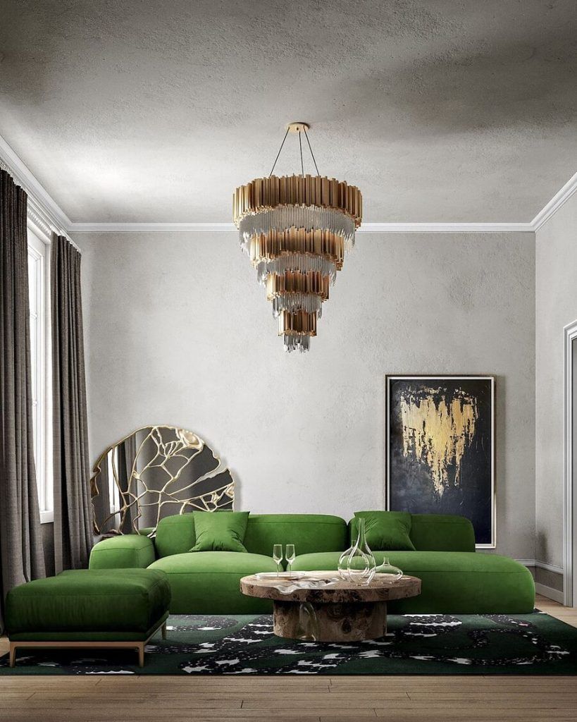 Een woonkamer met een groene bank en een kroonluchter aan het plafond.