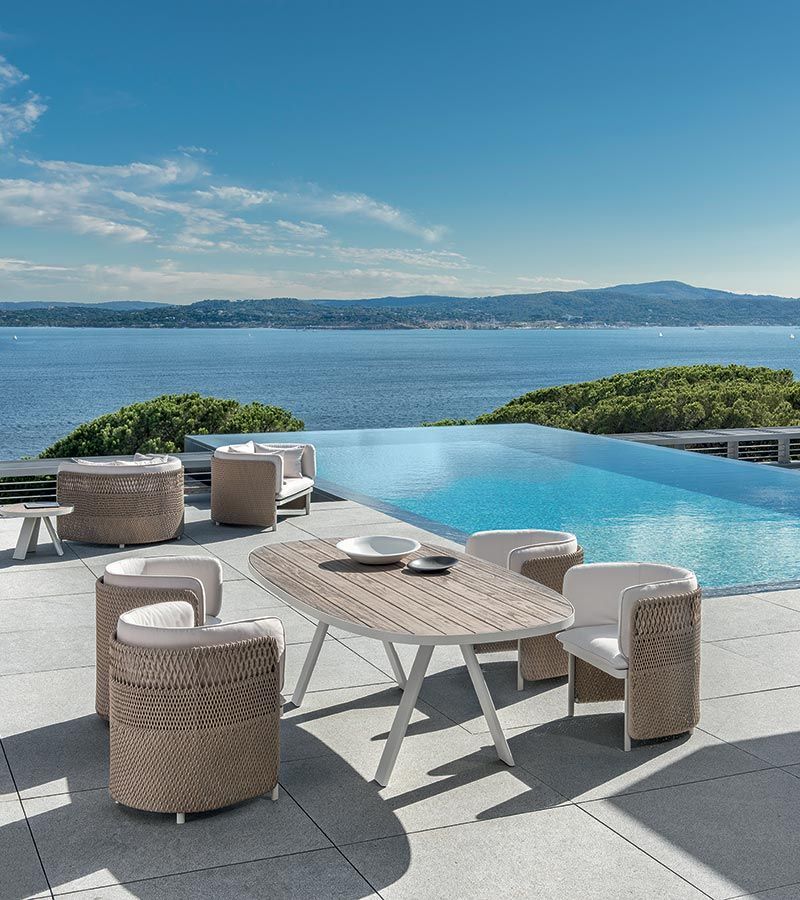 Een tafel en stoelen op een terras met uitzicht op de oceaan
