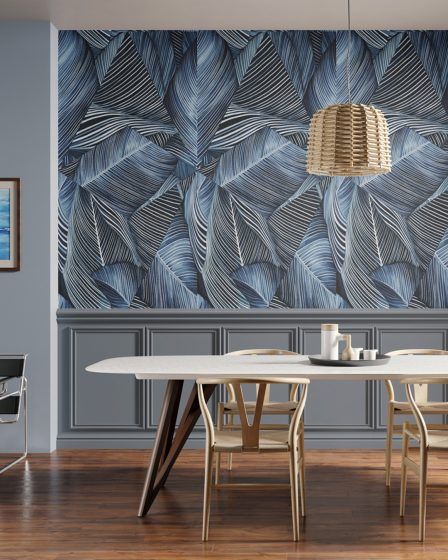 Een eetkamer met een tafel en stoelen voor een muur met veren erop.