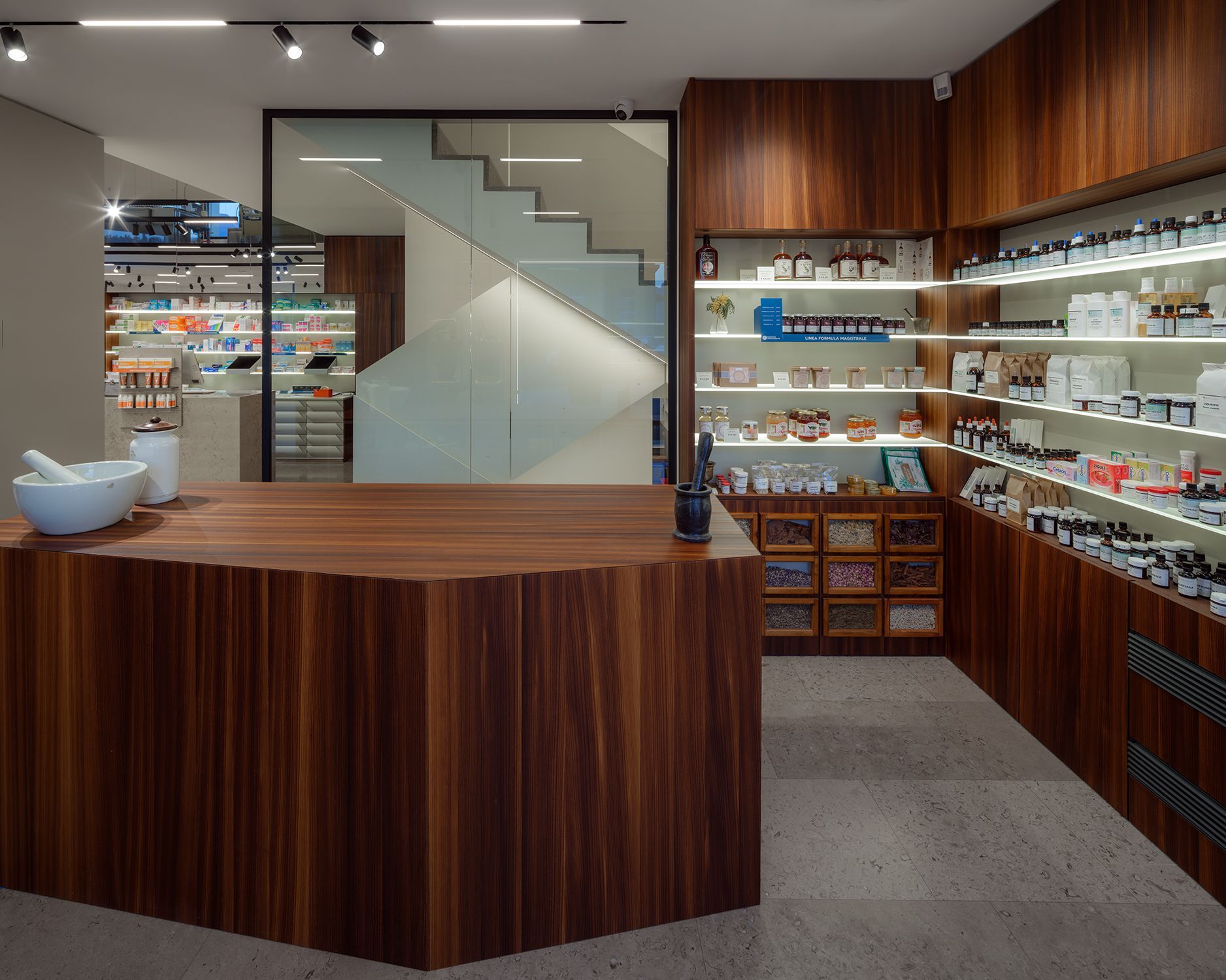 Een apotheek met een houten toonbank en planken vol flessen