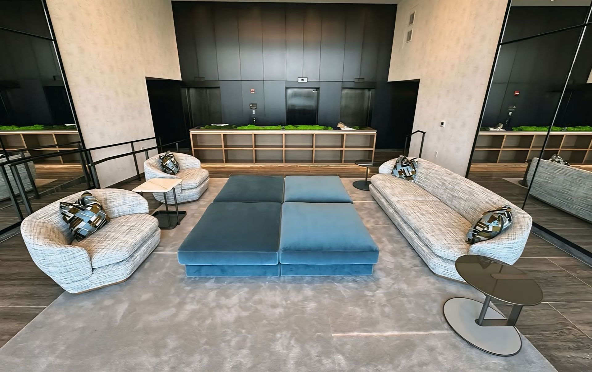 Een woonkamer met een bank, stoelen, een voetenbank en tafels.