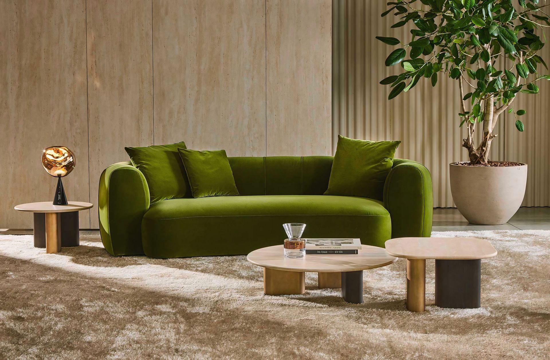 Een woonkamer met een groene bank en twee salontafels.