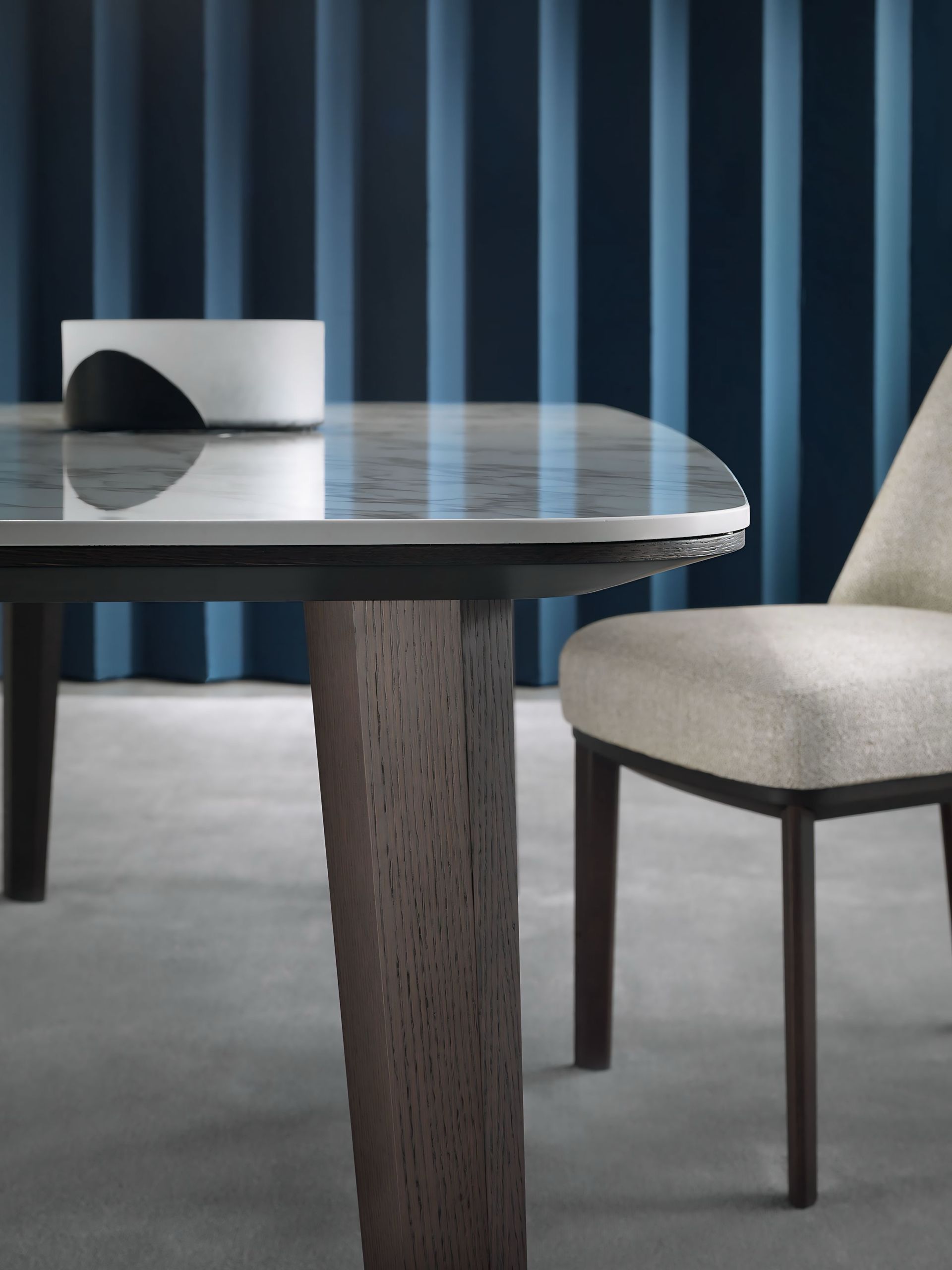 Een tafel en stoel voor een blauw gordijn