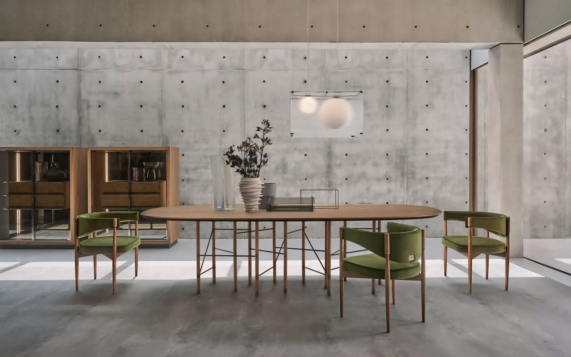 Een eetkamer met een tafel en stoelen en een betonnen muur