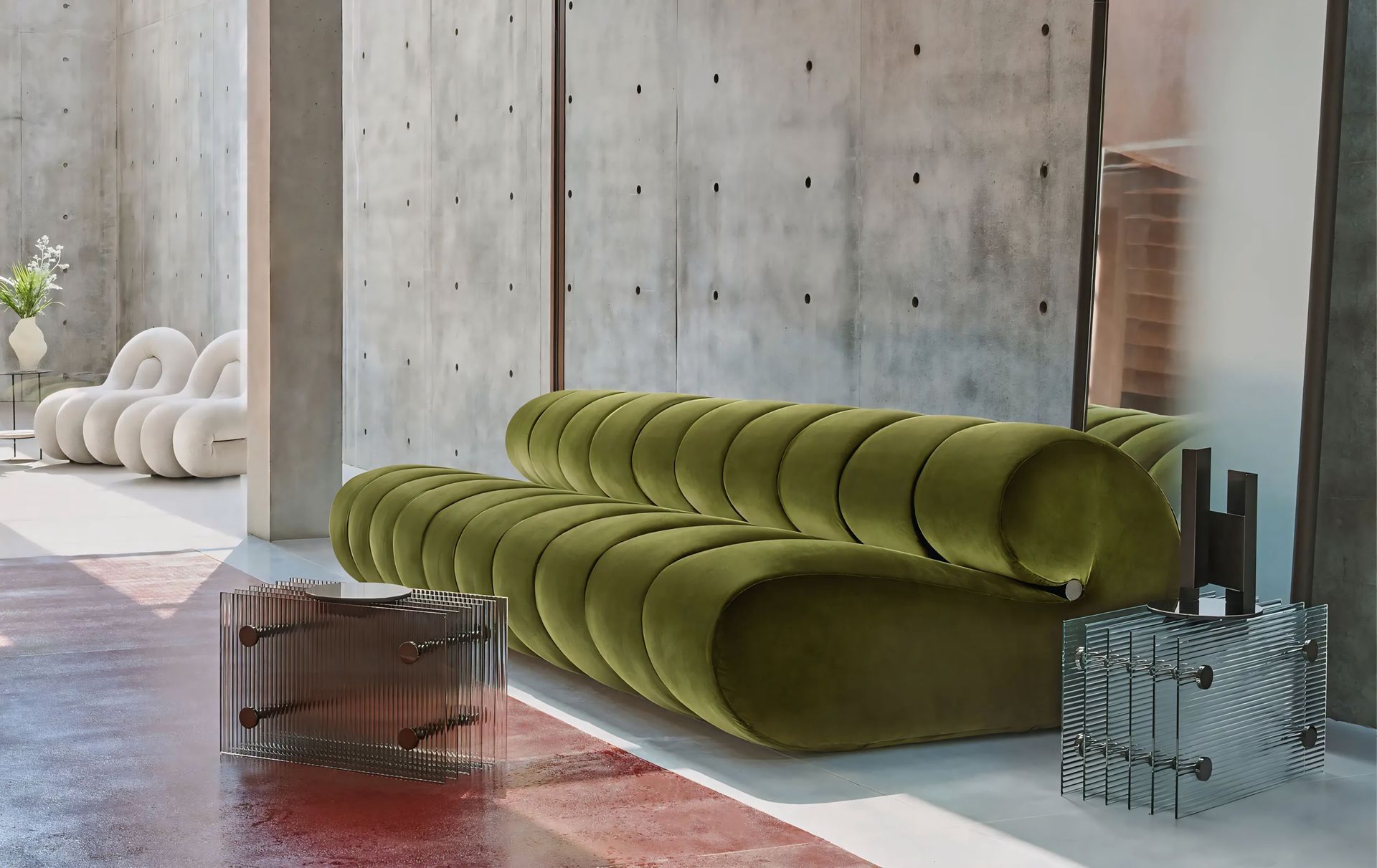 In de woonkamer staat een groene bank naast een glazen tafel.