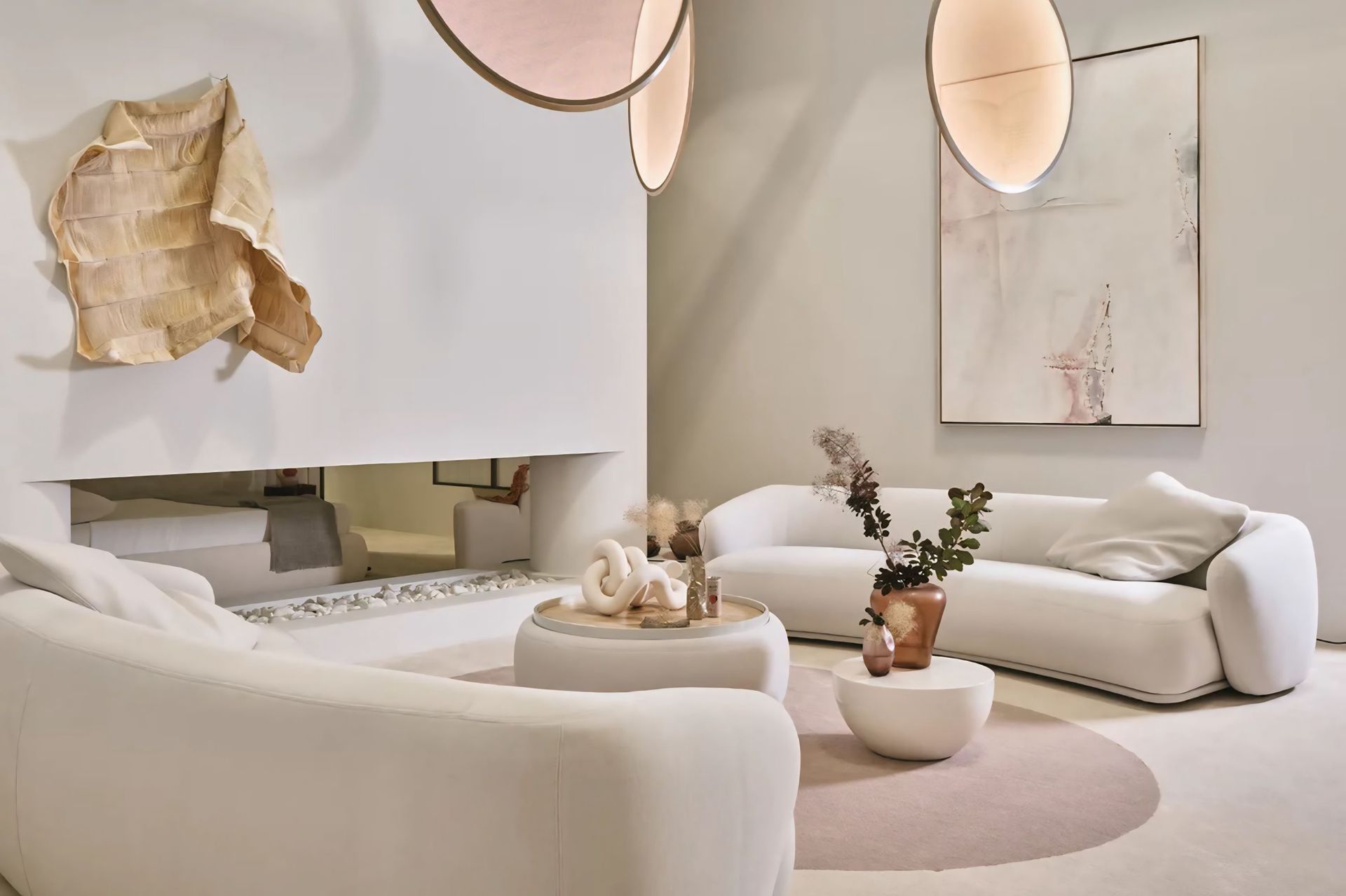 Een woonkamer met witte meubels en een open haard.