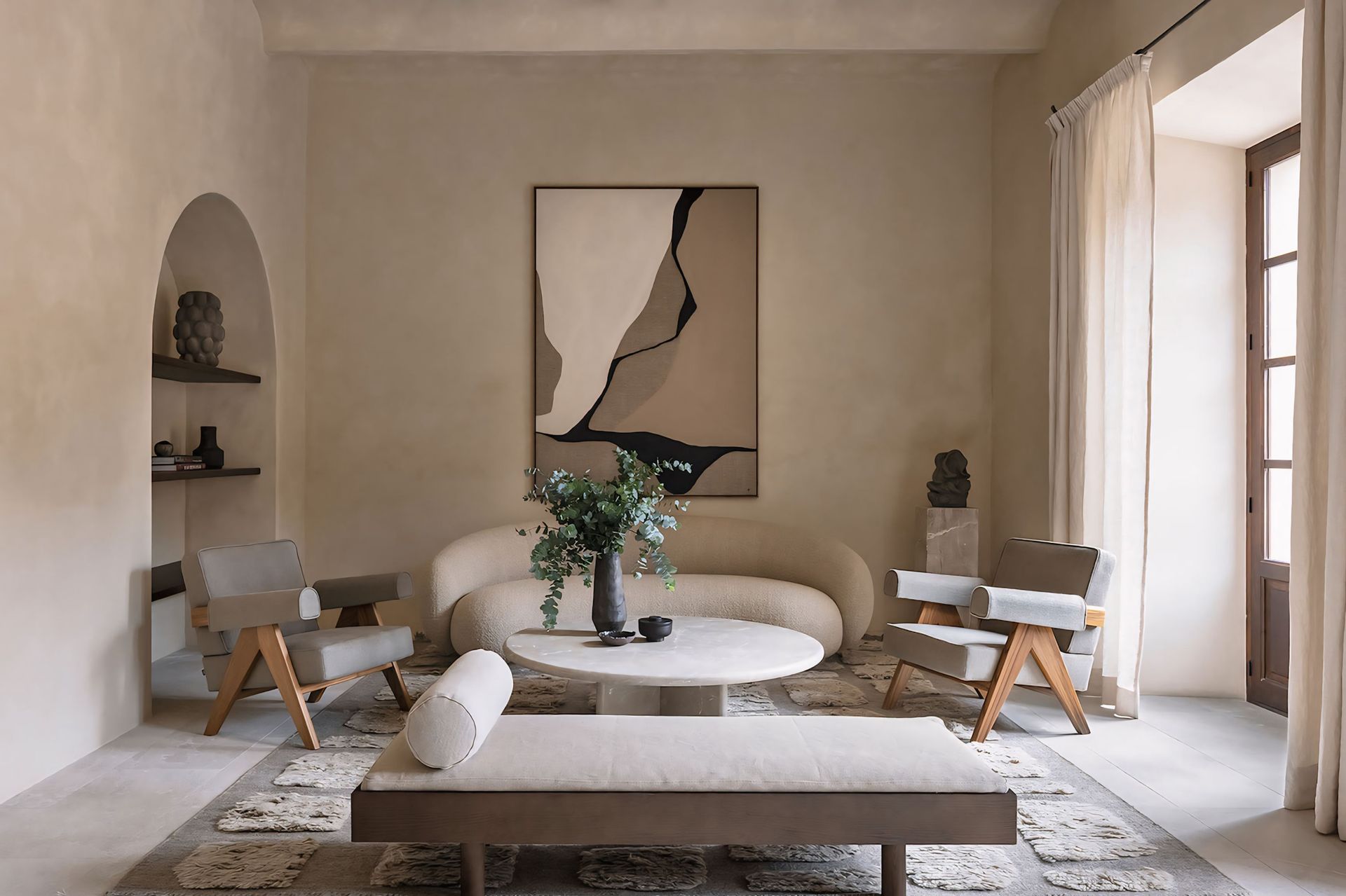 Een woonkamer met een bank, stoelen, een tafel en een schilderij aan de muur.