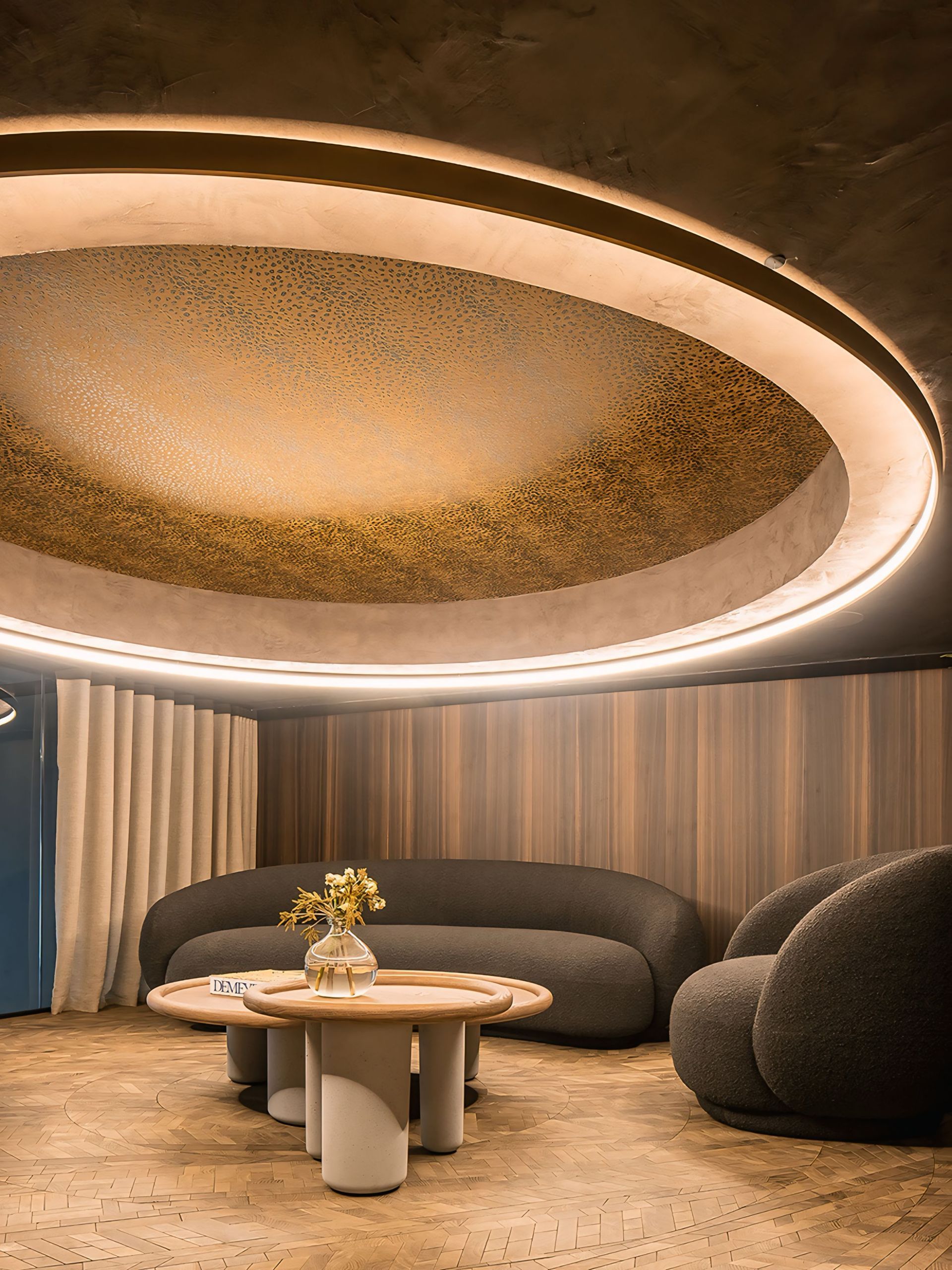 Een woonkamer met een bank, stoelen, een tafel en een rond plafond.