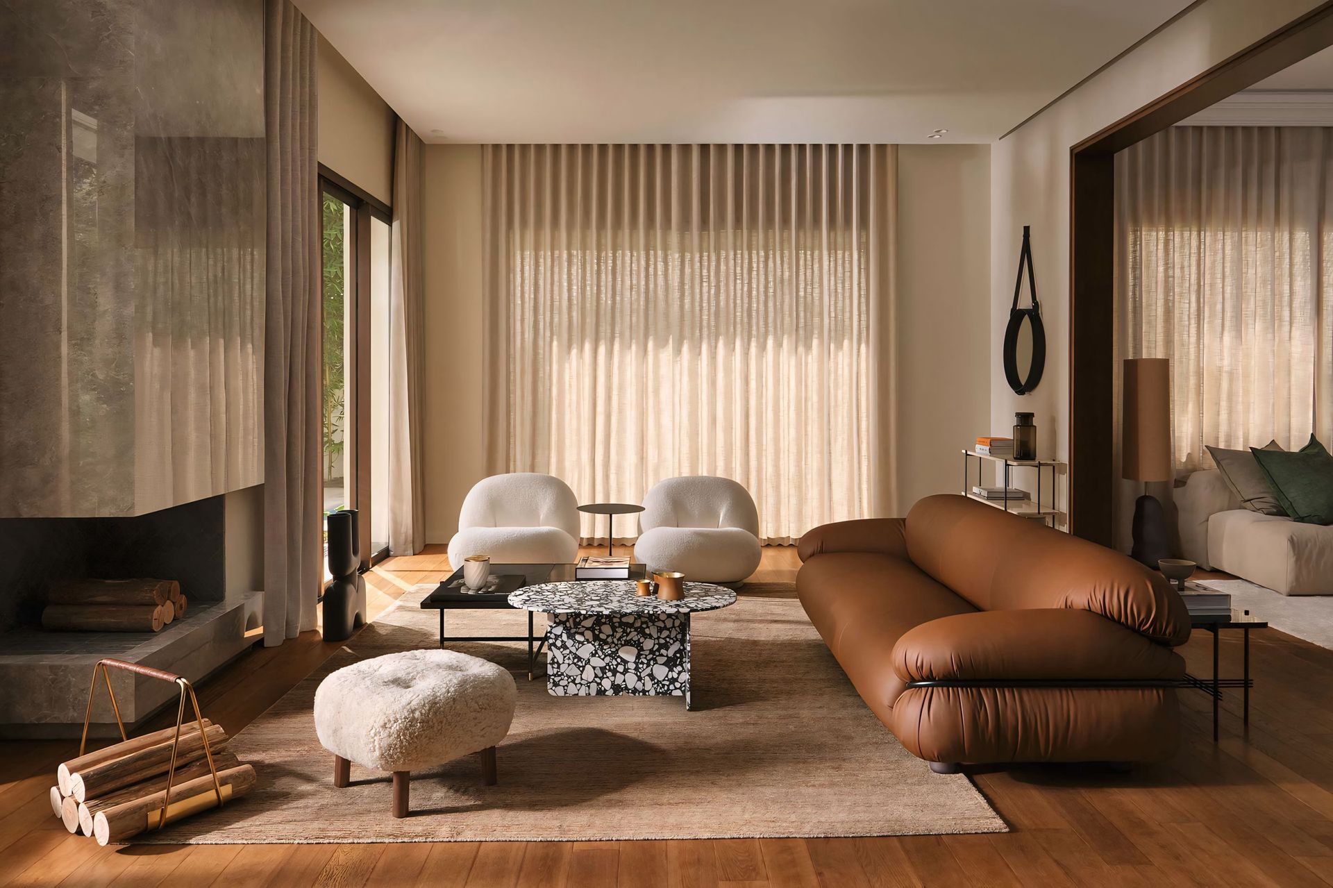Een woonkamer met een bruine bank, twee stoelen, een salontafel en een open haard.