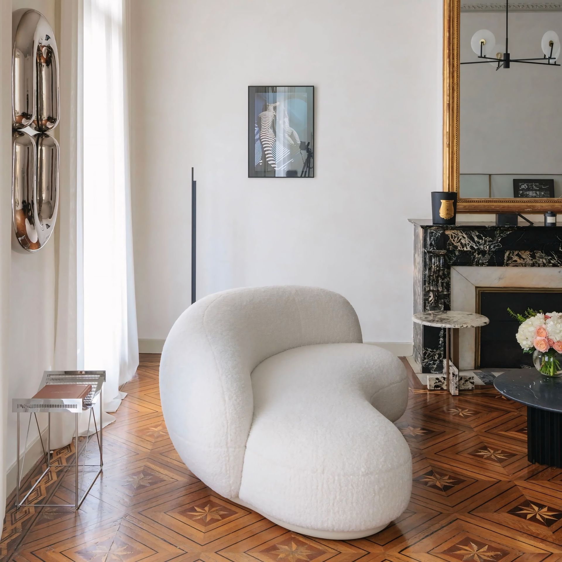 Een woonkamer met een witte stoel en een open haard