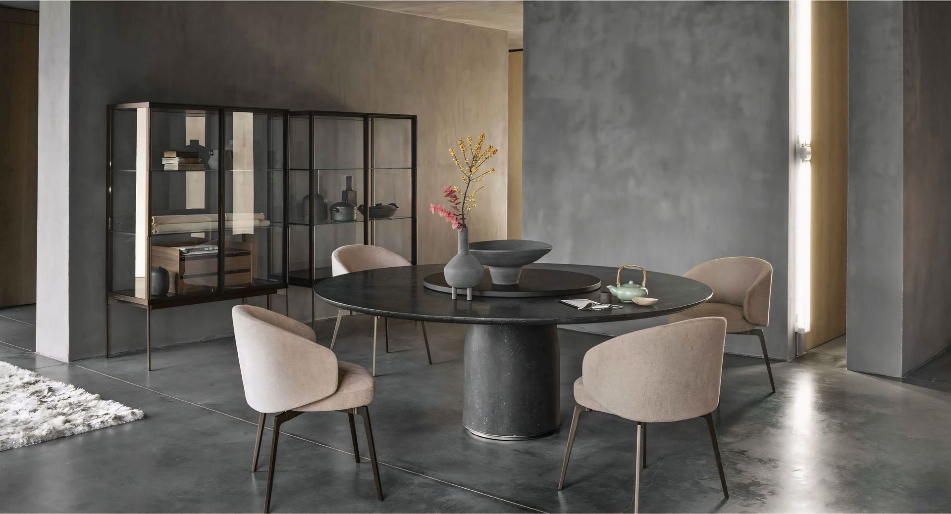 Een eetkamer met een ronde tafel en stoelen.