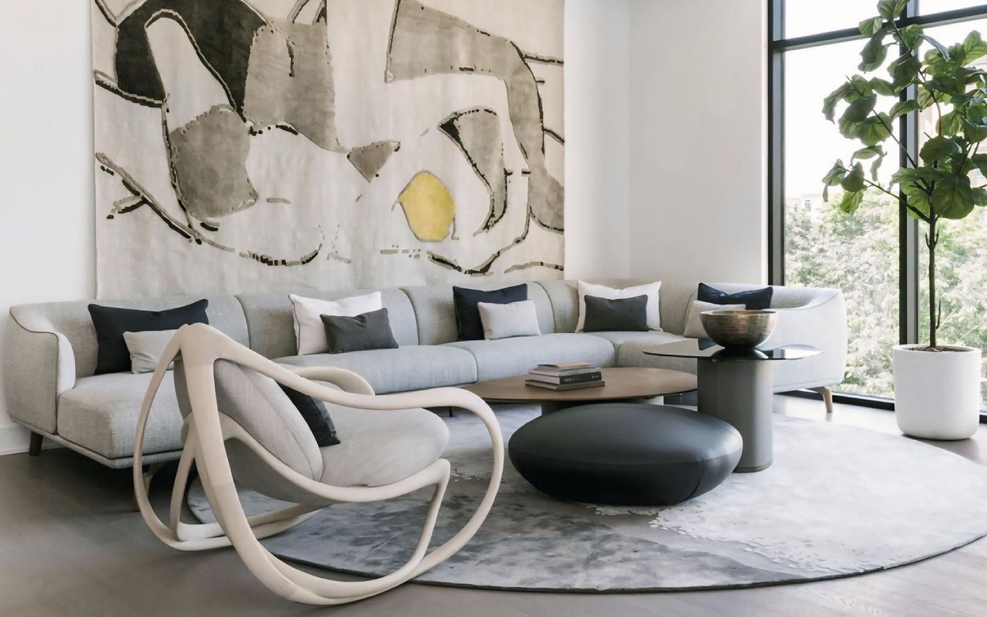 Een woonkamer met een bank, stoel, salontafel en een groot schilderij aan de muur.