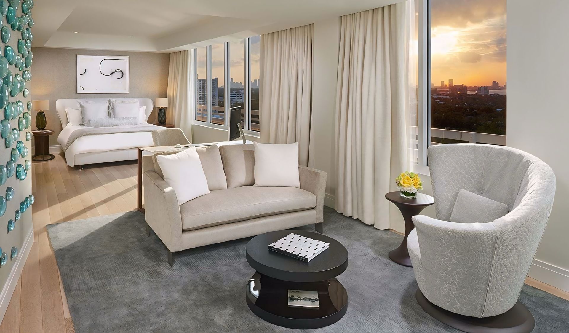 Een hotelkamer met een bank, stoel, salontafel en bed.
