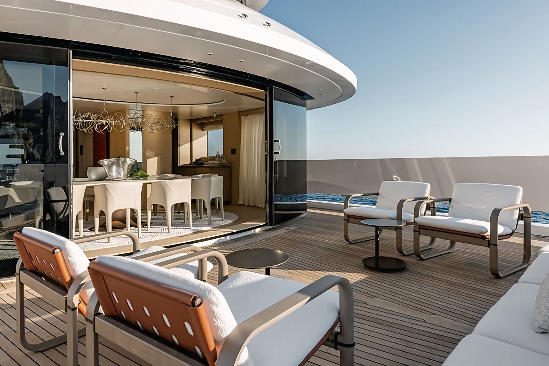 Een groot jacht met een terras met stoelen en een tafel