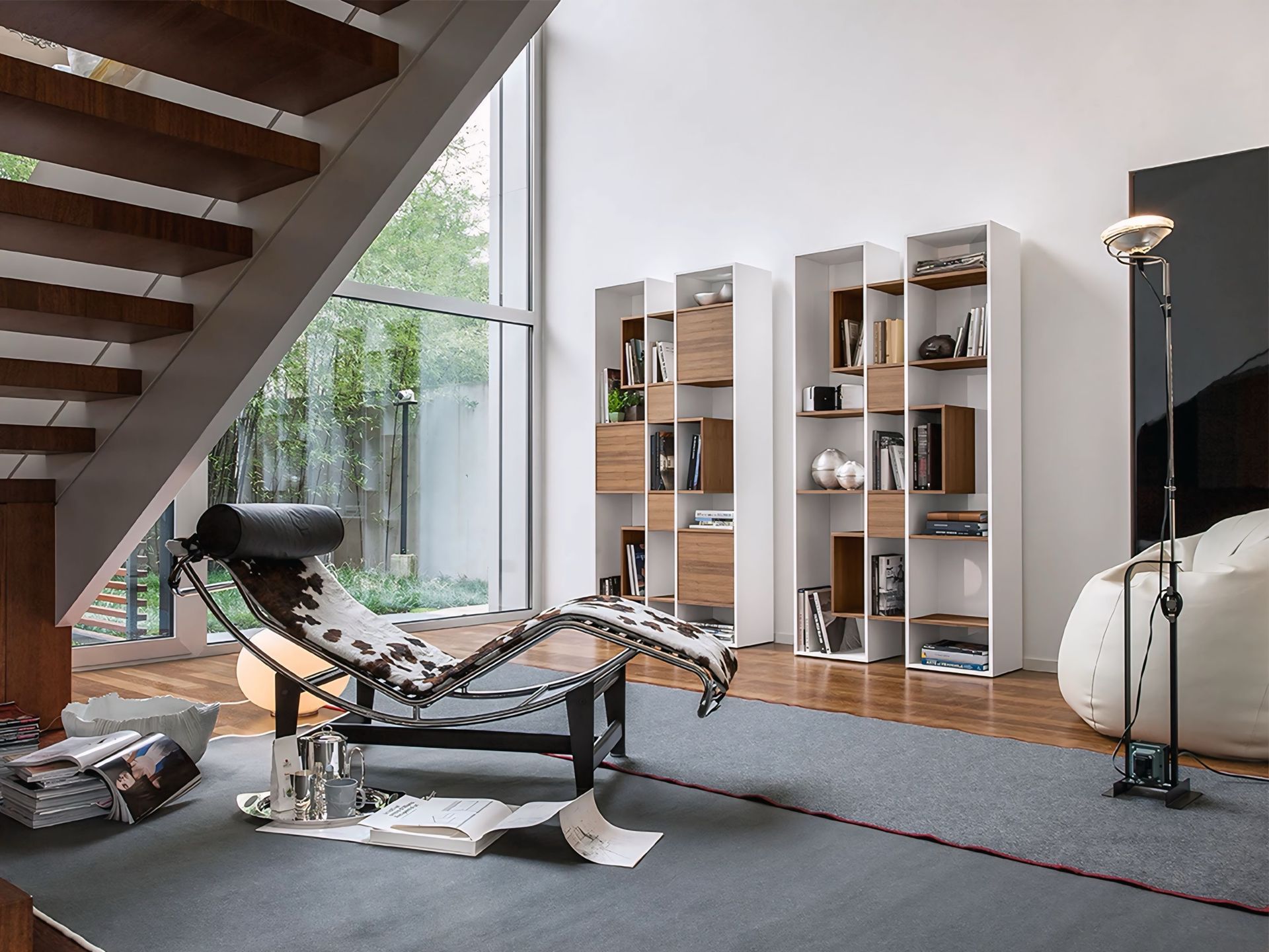 Een woonkamer met een chaise longue en boekenplanken