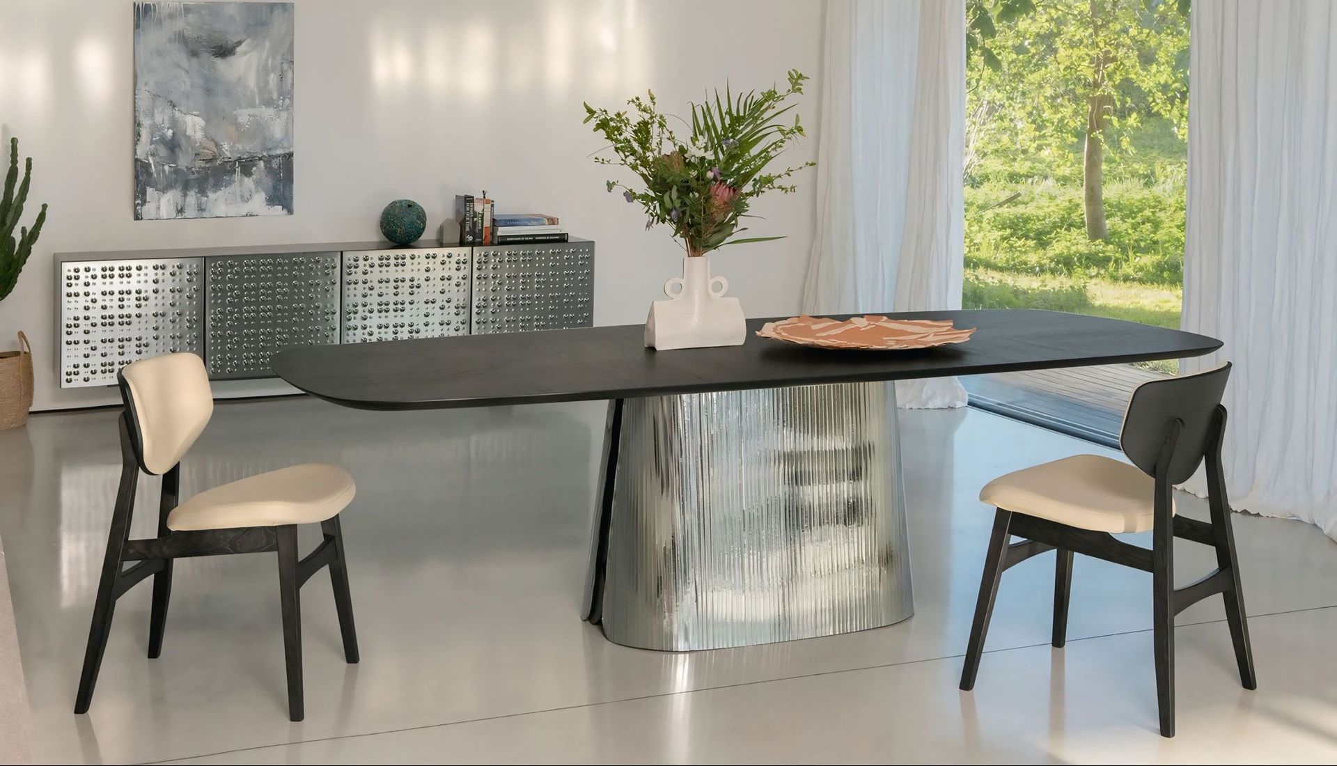 Een eetkamer met een zwarte tafel en twee stoelen