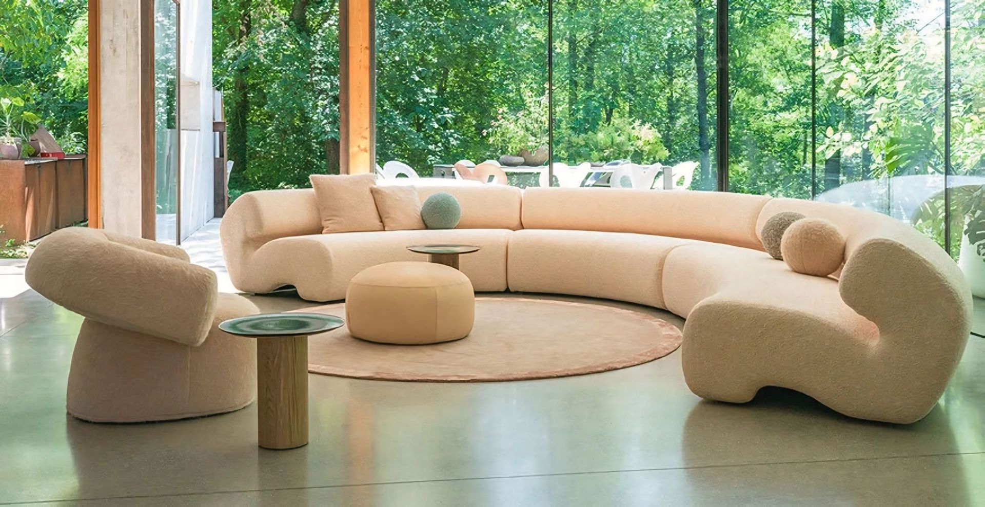 Een woonkamer met een bank, stoelen, voetenbankjes en een tafel.