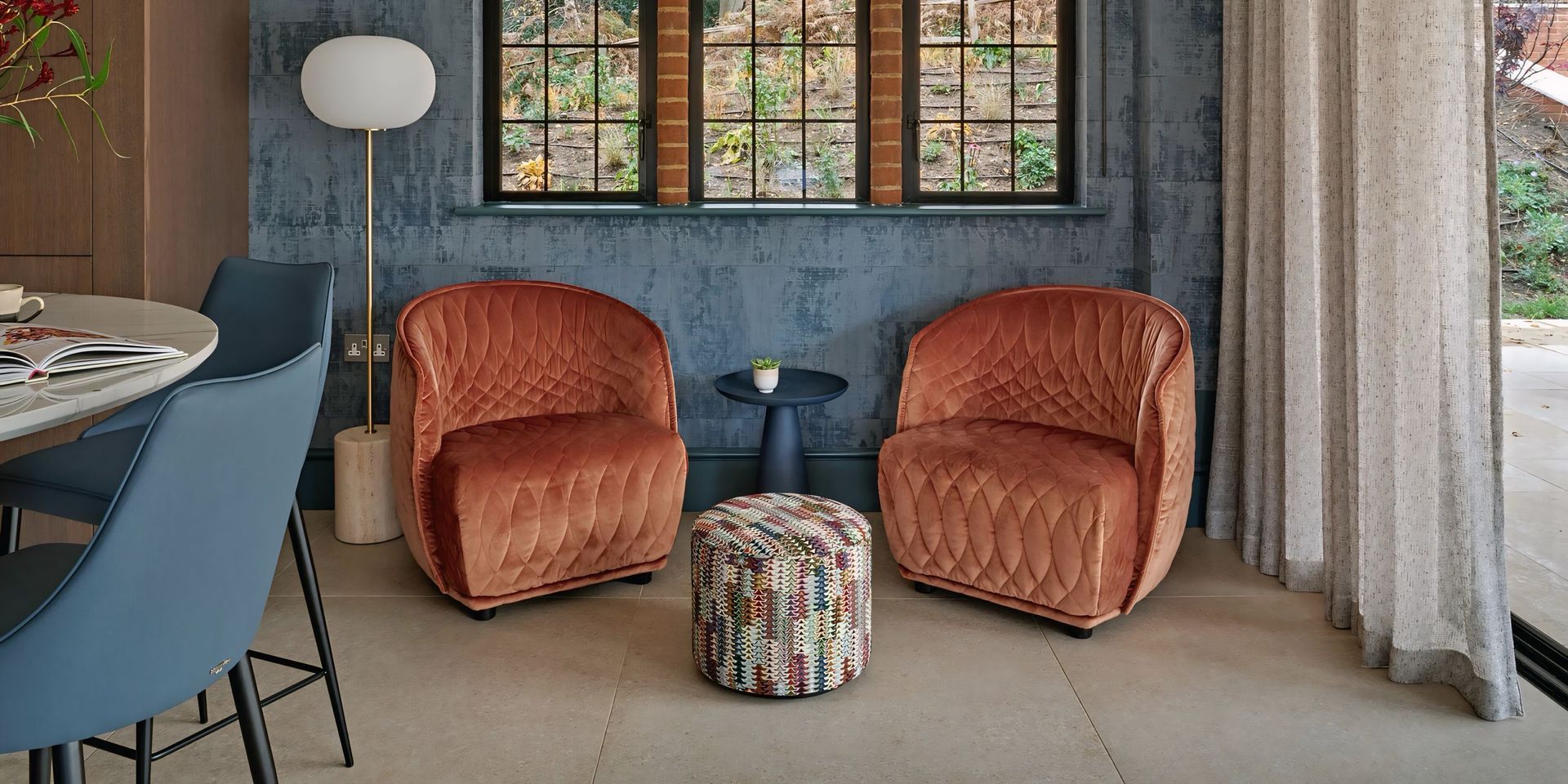 Er staan ​​twee stoelen en een tafel in de kamer.