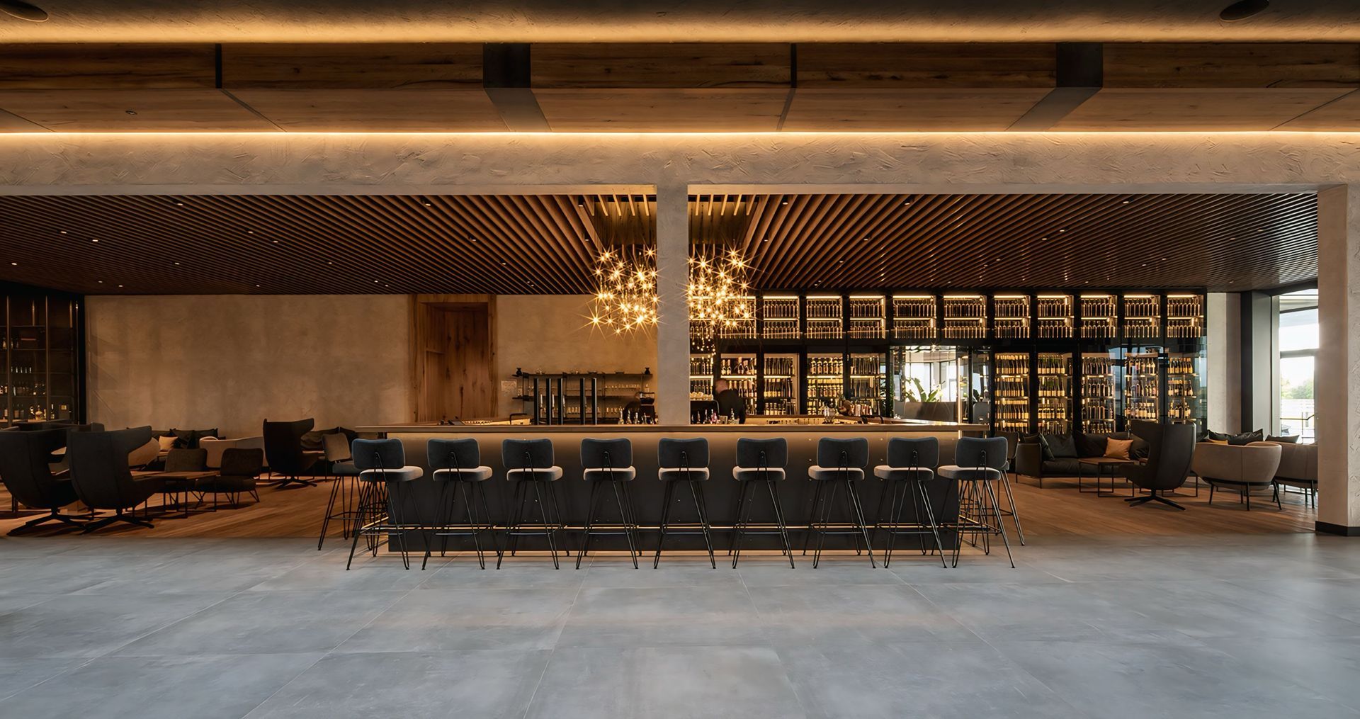 Een impressie van een restaurant met een lange bar en stoelen.