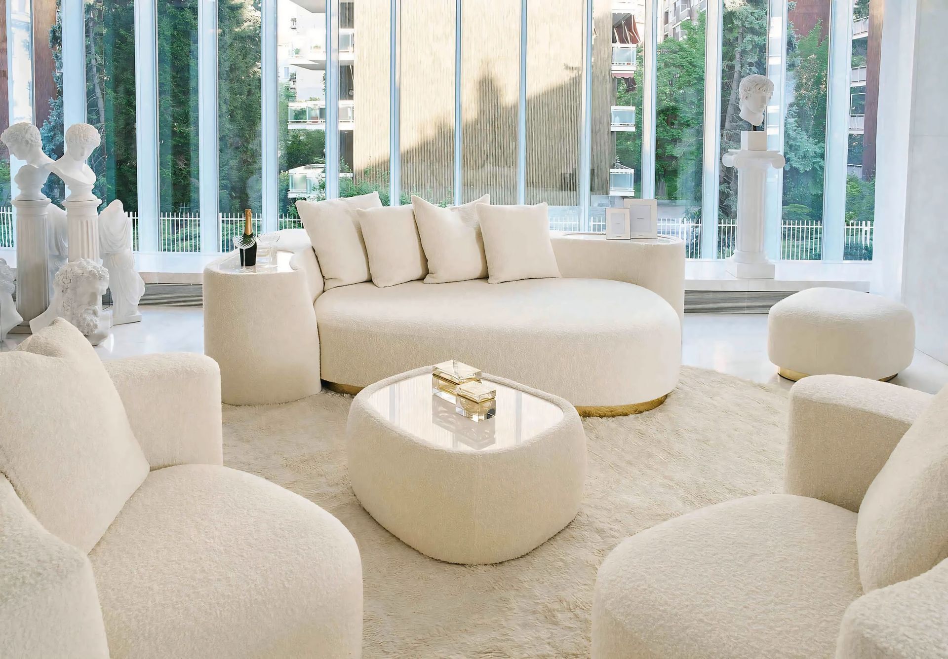 Een woonkamer met witte meubels en een ronde bank