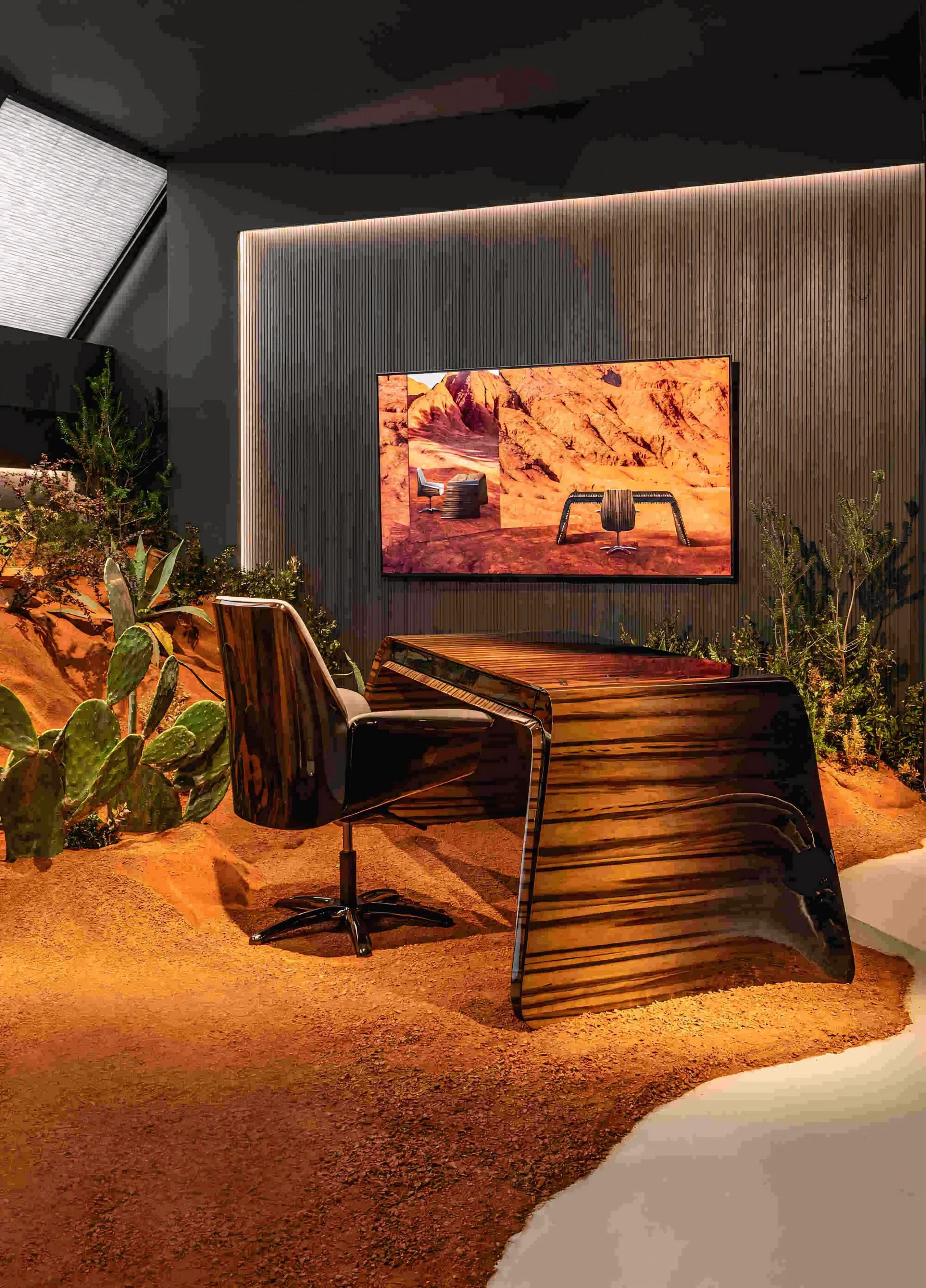 Een kamer met een bureau, stoel, televisie en cactus.