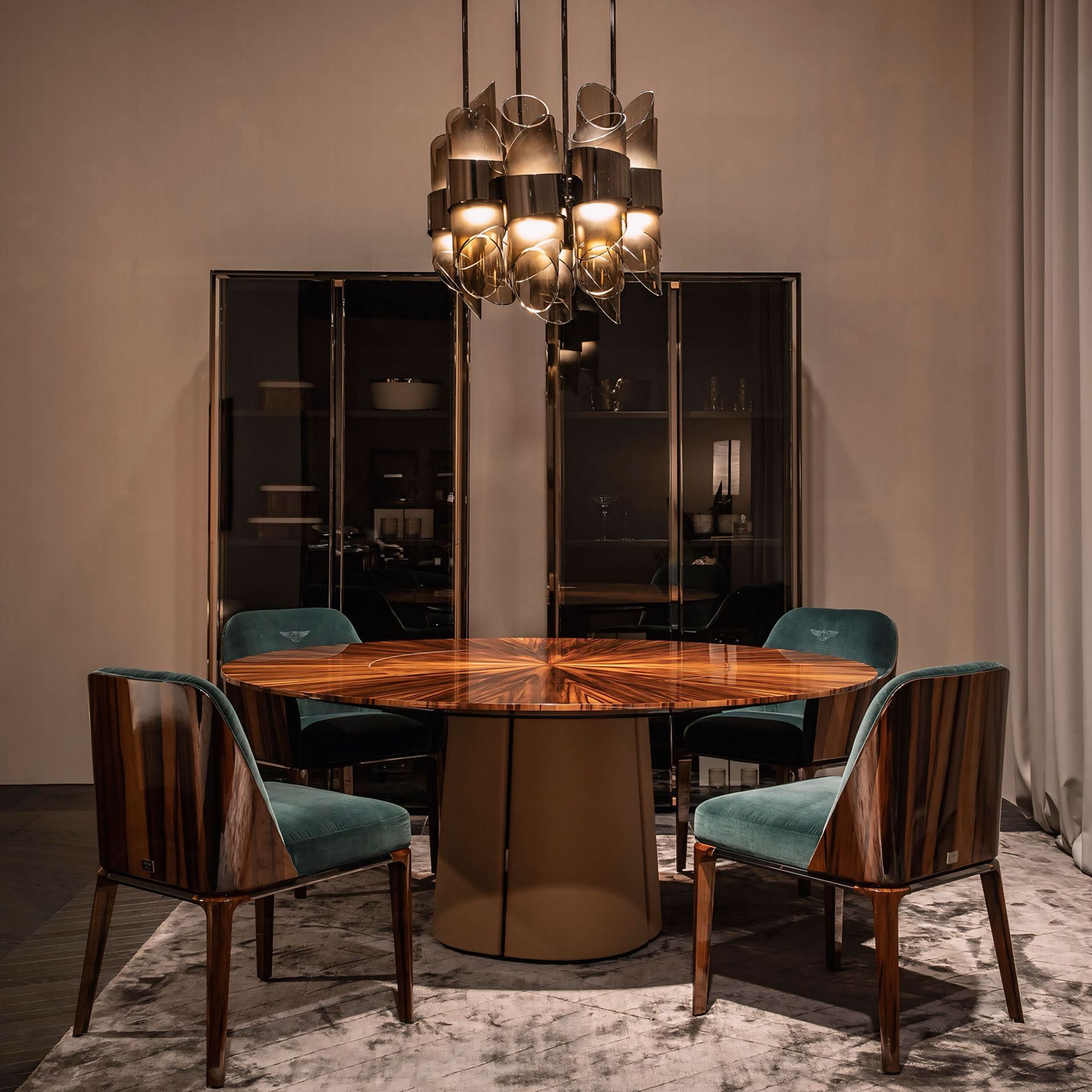 Een eetkamer met een ronde tafel, stoelen en een kroonluchter.