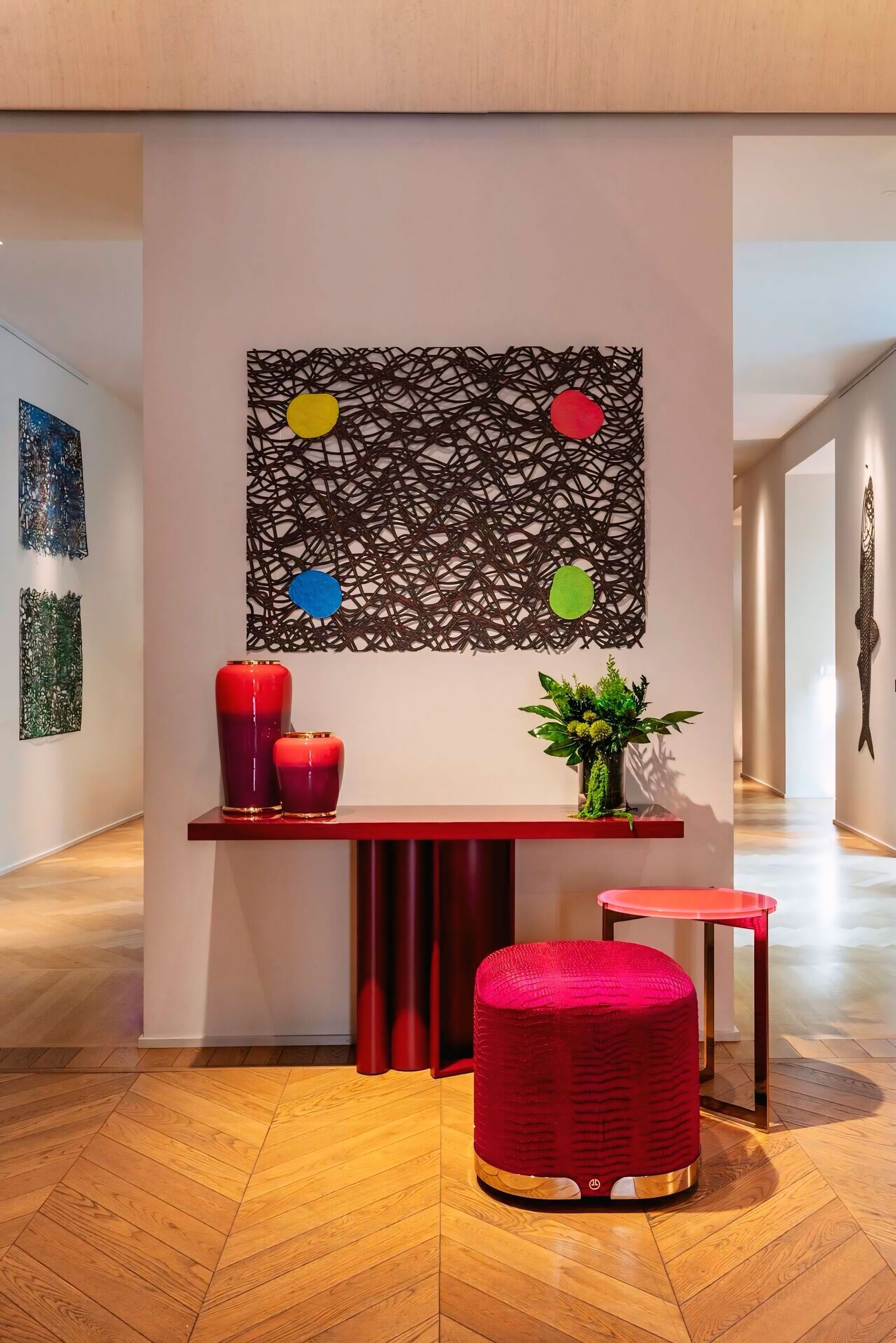 Een hal met een tafel, een voetenbankje, vazen ​​en een schilderij aan de muur.