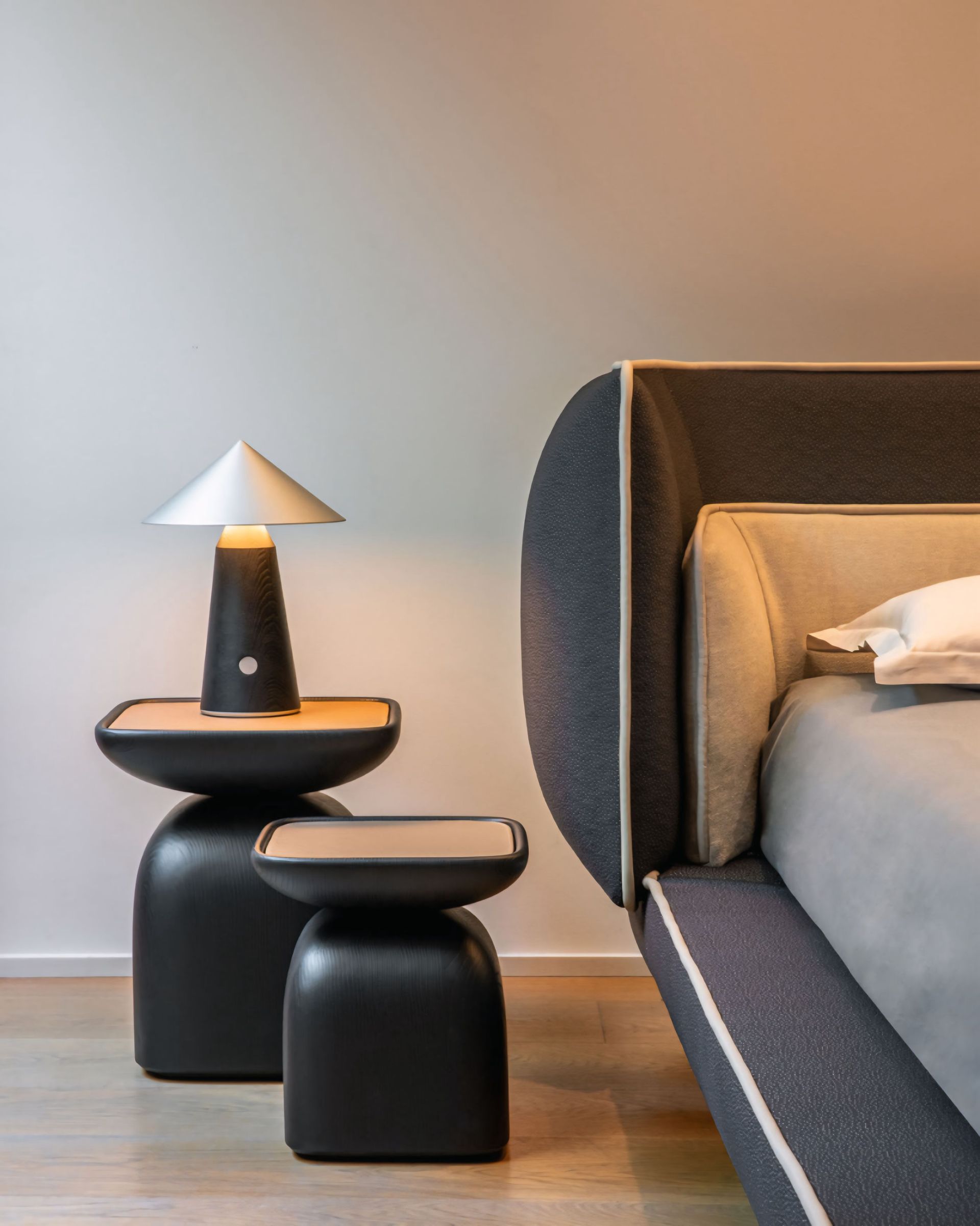 Een slaapkamer met een bed en twee tafels met lampen erop