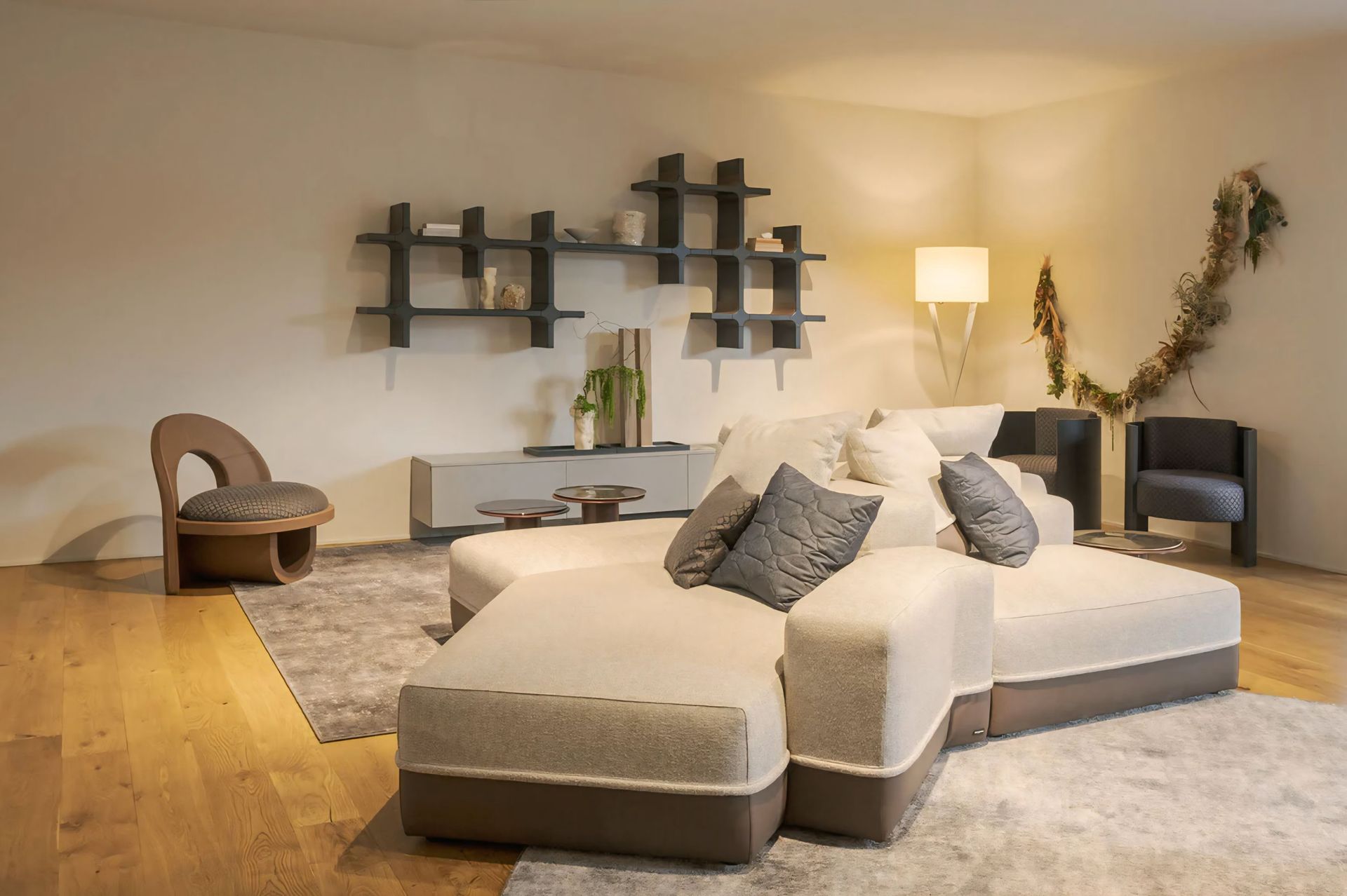 Een woonkamer met een bank, stoelen, planken en een lamp.